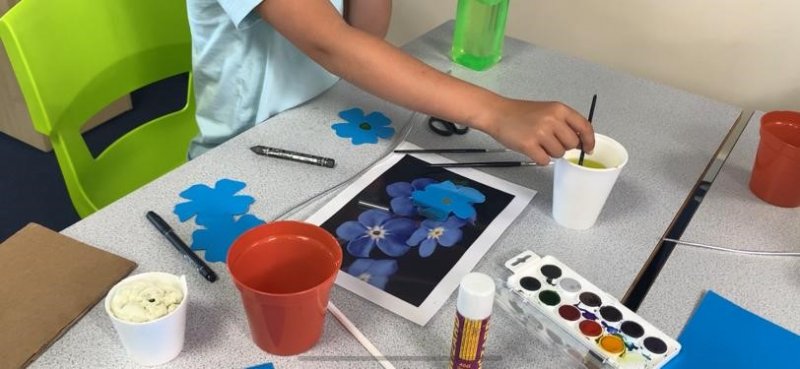 child painting a flower