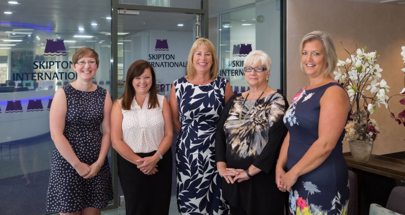 Five women photographed in Skipton International Limited's lobby