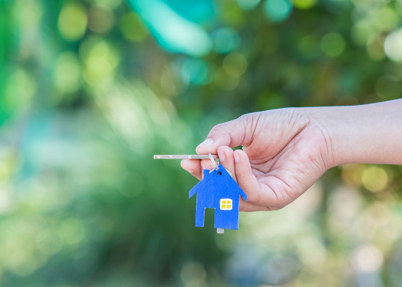 people holding keys with house keychain
